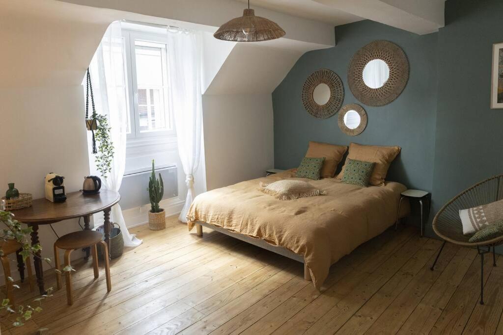 贝桑松Charmant cocon centre historique的一间卧室配有一张床、一张桌子和镜子