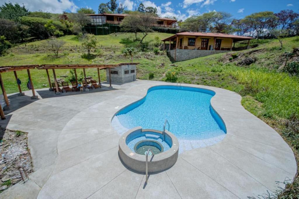 洛哈Vilcabamba casa / granja Vilcabamba house / farm的一座带房子的庭院内的游泳池