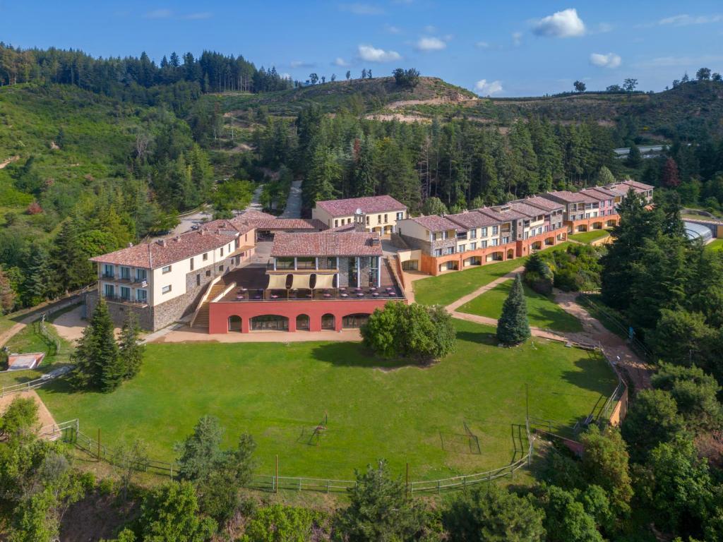圣伊拉里奥-萨卡尔姆Vilar Rural De Sant Hilari Sacalm by Serhs Hotels的山丘上大房子的空中景色