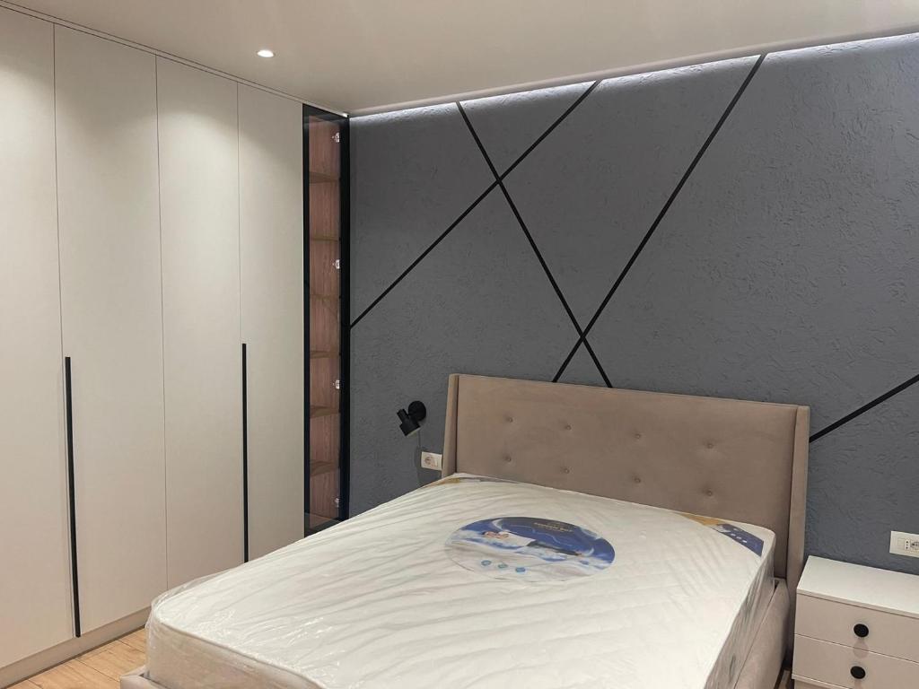 都拉斯Emi Apartment的卧室配有一张床铺,位于带墙壁的房间