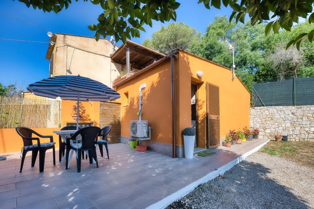 阿祖罗港La Casina di Alan - Goelba的庭院配有桌椅和遮阳伞。