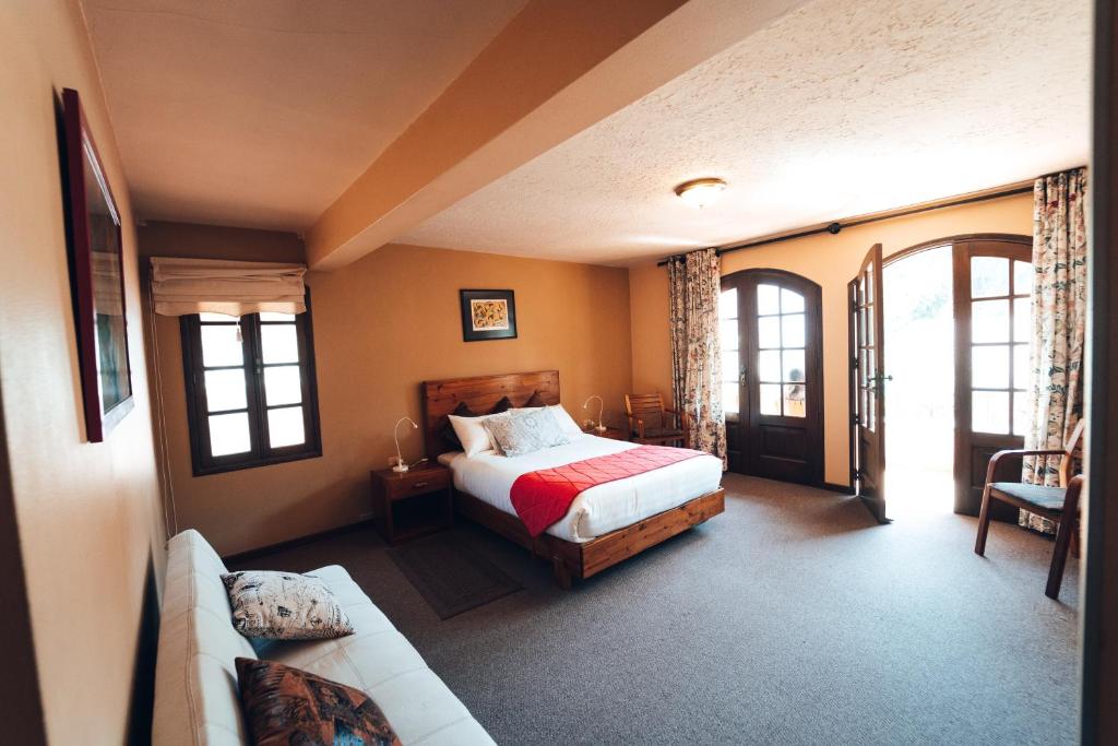 科恰班巴Hotel Boutique La Casa de Margarita的一间卧室配有一张床和一张沙发