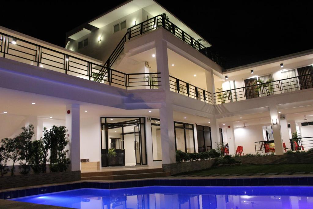达沃市贝莹套房公寓式酒店的一座在晚上设有游泳池的大房子