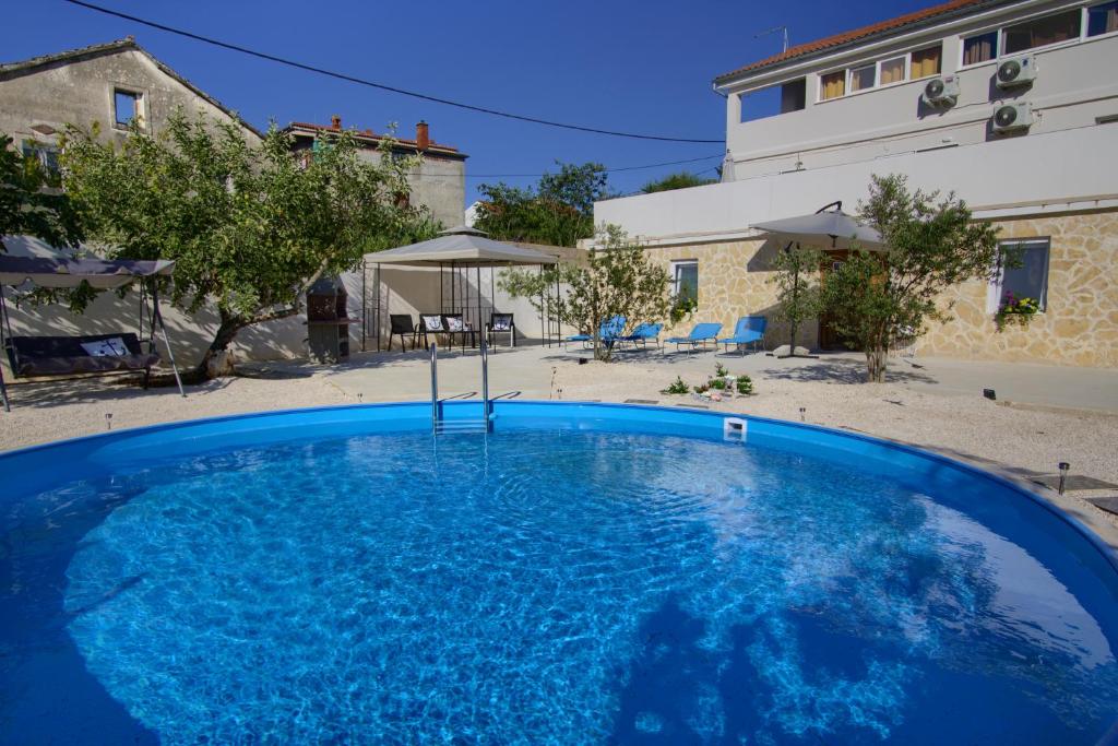 班吉Apartments Villa Mihaela的大楼前方的大型蓝色游泳池