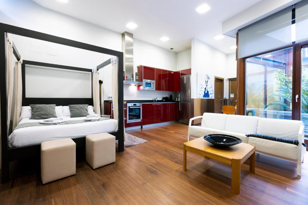 宏达瑞比亚Loft by Basquelidays的一间卧室配有一张床、一张沙发和一张桌子