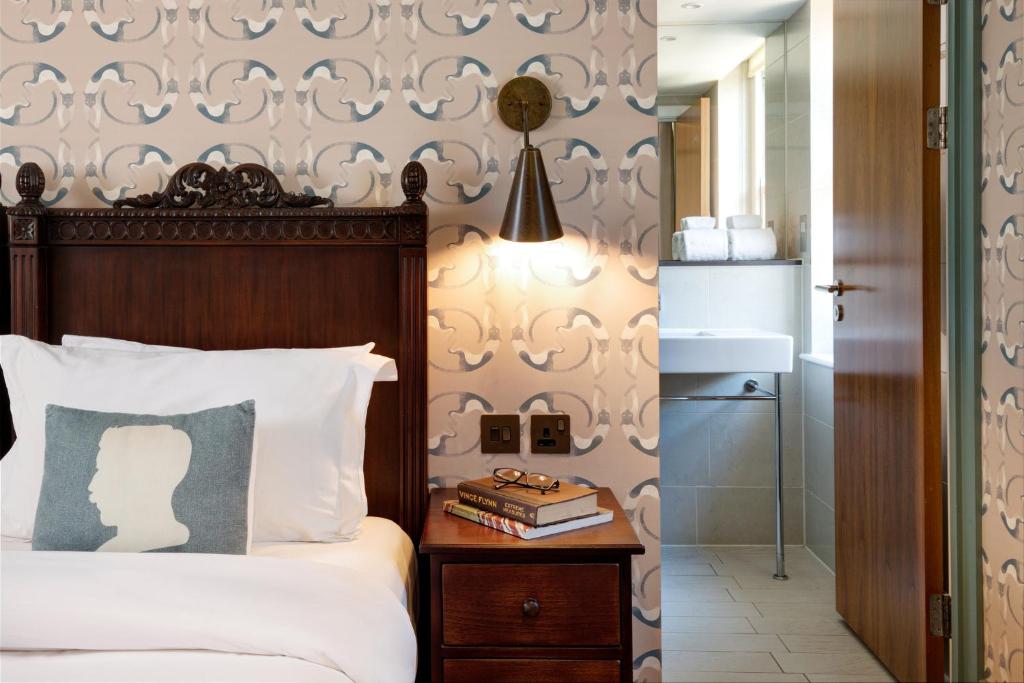 伦敦Morton Hotel的一间卧室配有床和一张带书籍的边桌
