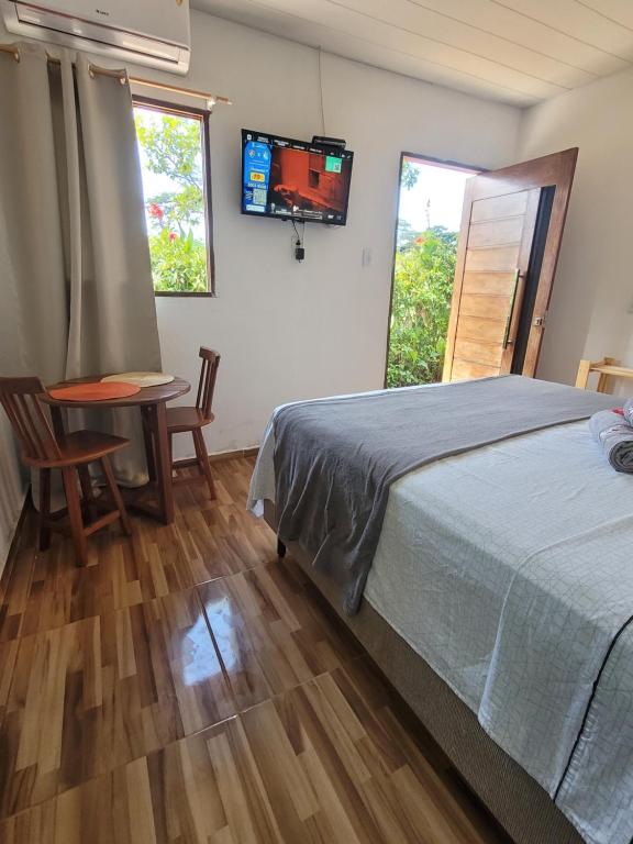 费尔南多 - 迪诺罗尼亚Batera House Noronha的一间卧室配有一张床、一张桌子和一个窗户。