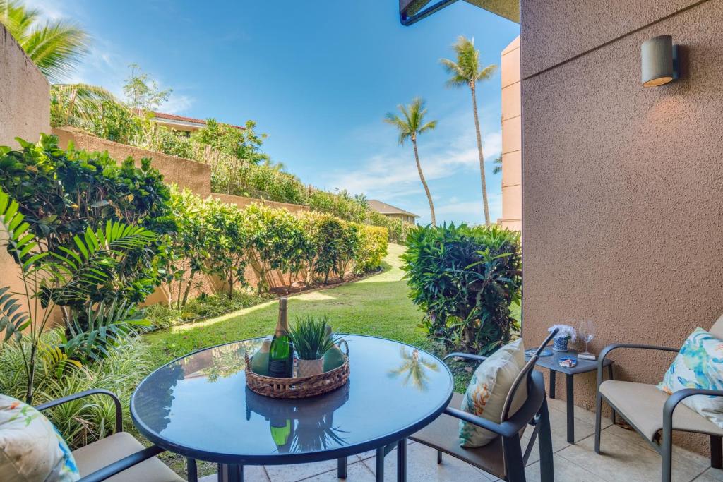 卡哈纳Kahana Villa E111的一个带桌椅和棕榈树的庭院