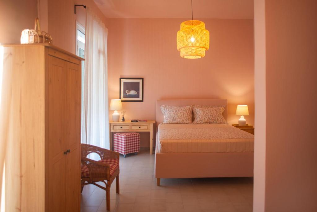 里科索翁Nina's apartment的一间卧室配有一张床、一把椅子和一个吊灯。