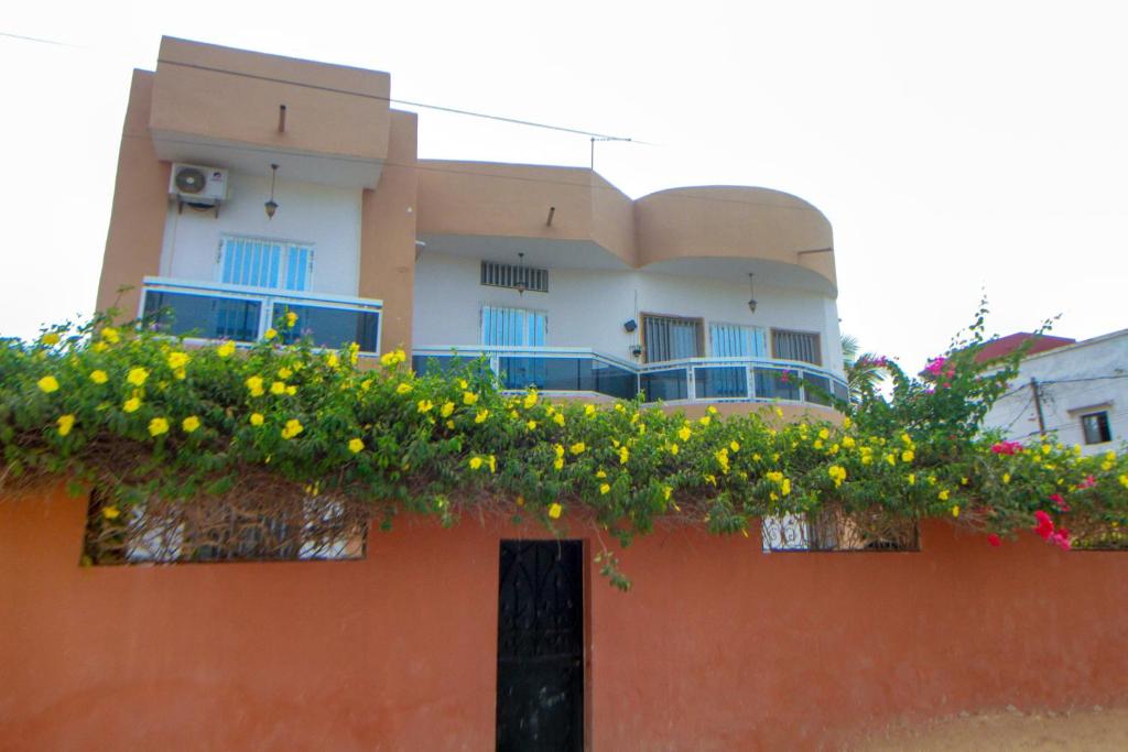 萨利波图尔"Ô soleil" une Villa moderne dans un quartier paisible du centre de Saly的一座花朵在上面的建筑