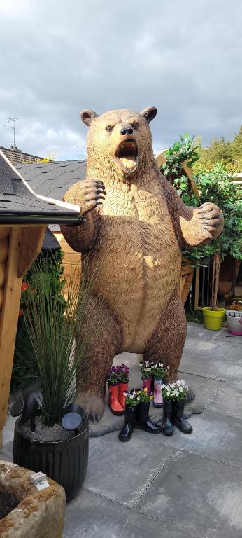 KeshFiddlers Cottage的一只熊的雕像,它拿着飞盘