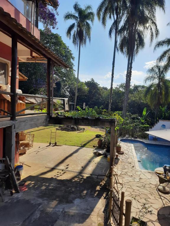 科蒂亚Chácara piscina aquecida的一个带游泳池和棕榈树的后院