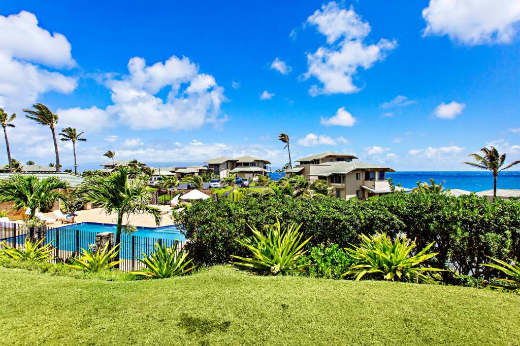 卡哈纳Kapalua Bay Villa 33G4的享有棕榈树度假村和大海的景致。
