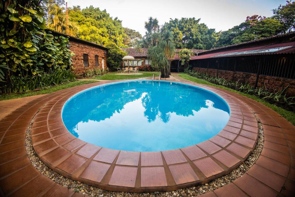 乌贝拉巴Paineiras Hotel Fazenda的一座砖砌建筑的院子内的游泳池
