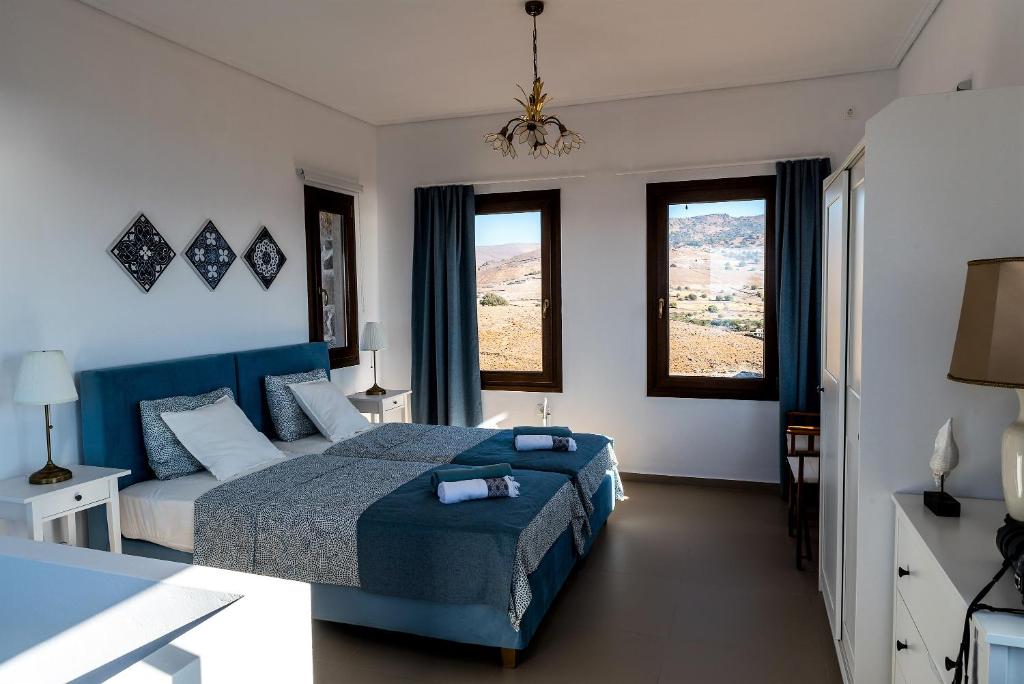 TavariSeaview Villa的一间卧室设有蓝色的床和2个窗户。