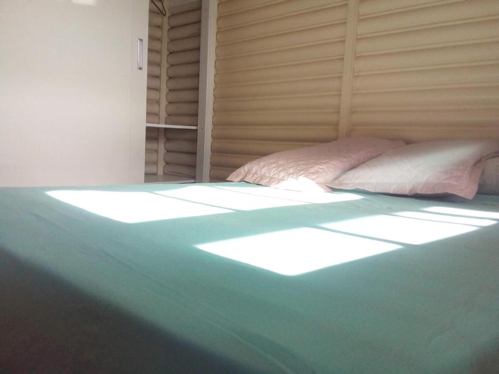 卡内拉Chalé alpino mobiliado perto do centro de canela rs的一间卧室,配有一张阳光明媚的床