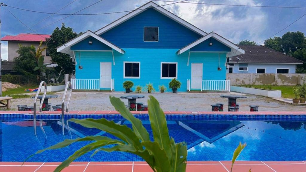 Kota BharuMembunga Village的蓝色的房子,前面有一个游泳池