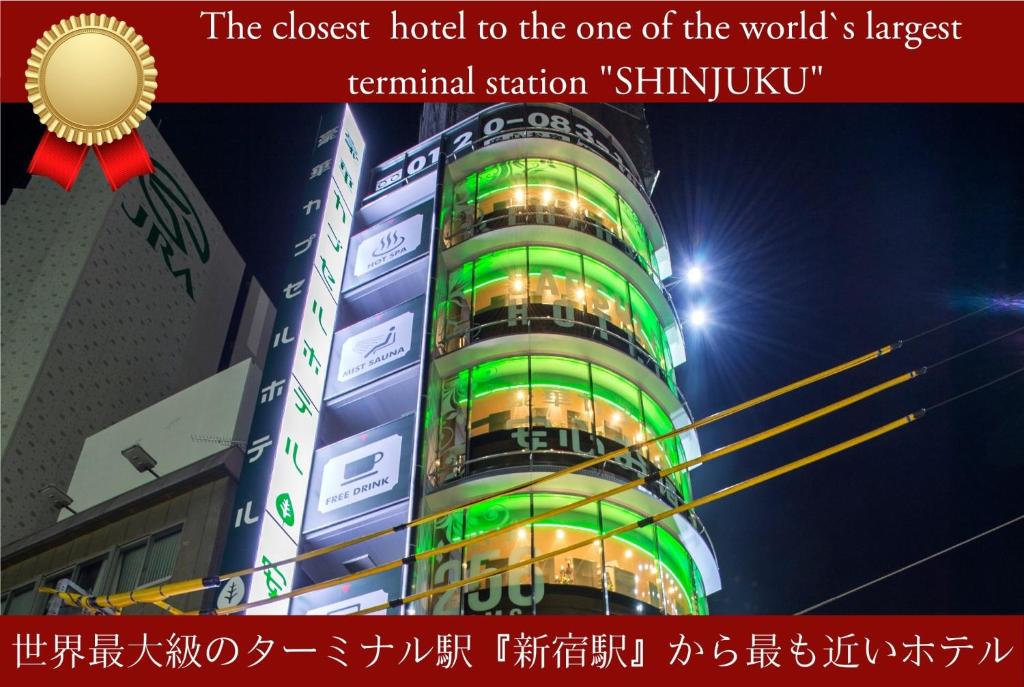 东京Anshin Oyado Tokyo Shinjuku Ekimaeten - Male Only的建筑的一侧有绿灯