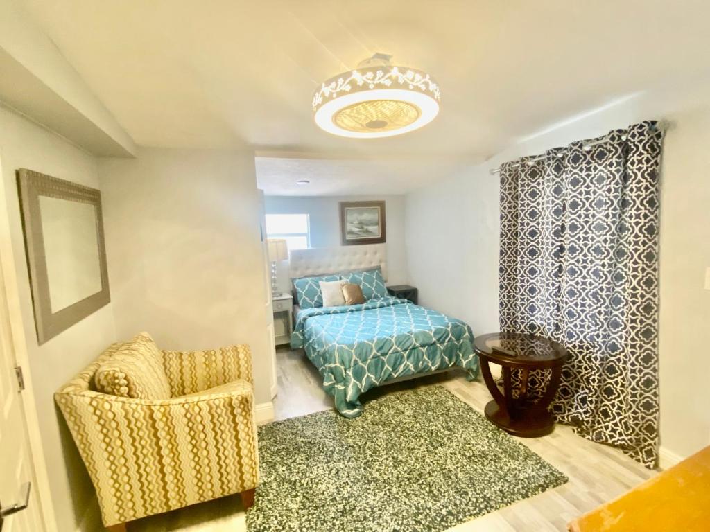 沃思湖Private Retreat的一间卧室配有一张床、一把椅子和一个吊灯。