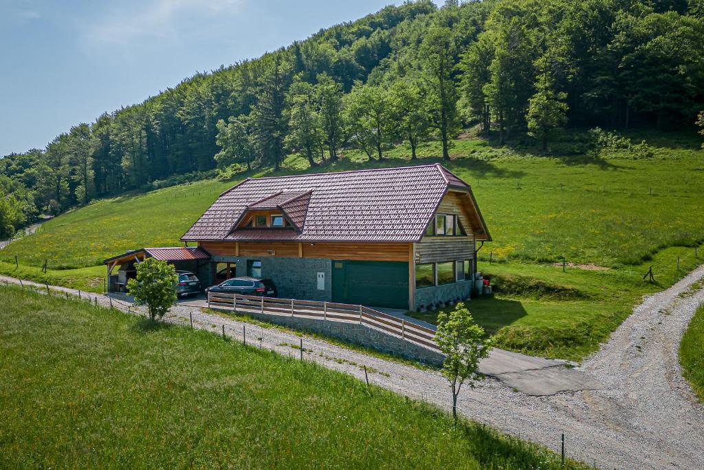 罗加斯卡斯拉提纳Ranch Stojnšek House With Sauna - Happy Rentals的山丘上的房子,旁边停有一辆汽车