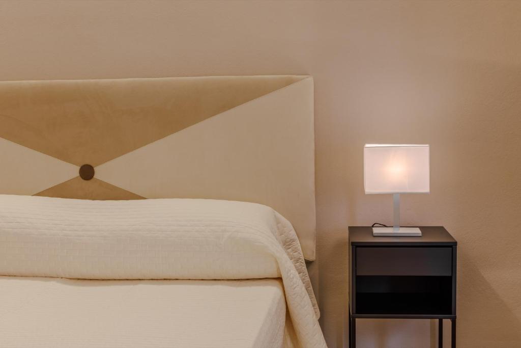 蒙特卡蒂尼泰尔梅阿拉西奥酒店的一间卧室配有一张床,床头柜上配有一盏灯