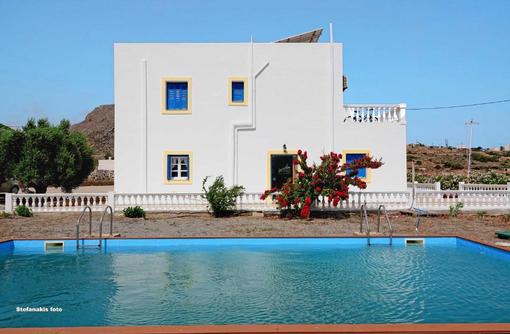 Agía MarínaAerikohotel - Apartments的房子前面的房子和游泳池