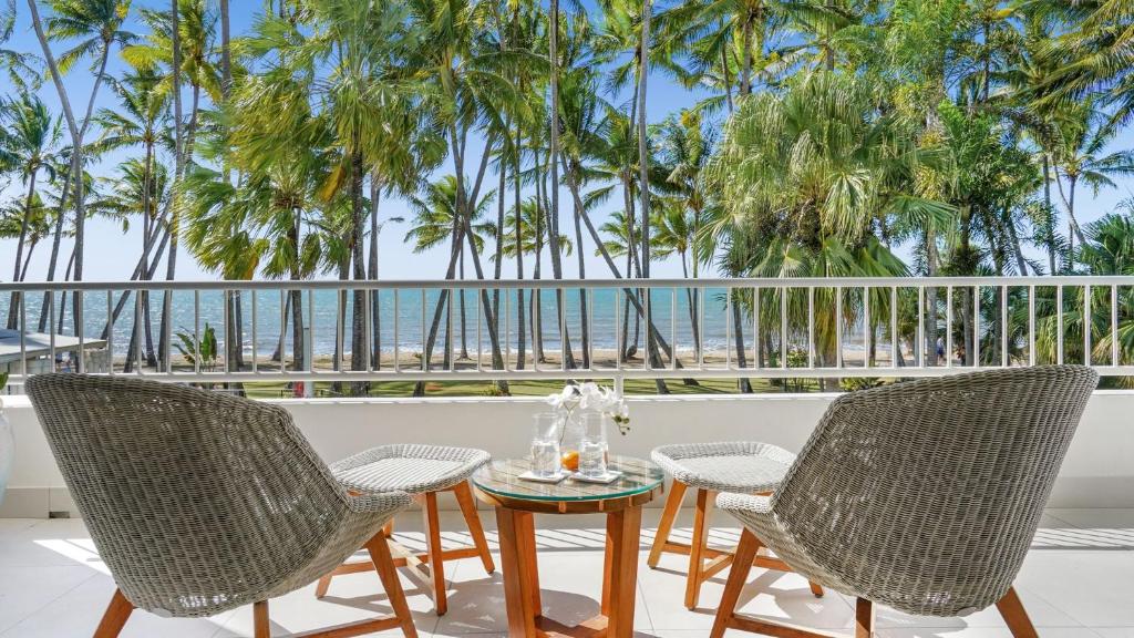 棕榈湾Belle Escapes presents 14 Alamanda Resort Where Pure Luxury meets the Coral Sea的海滩景阳台配有桌椅