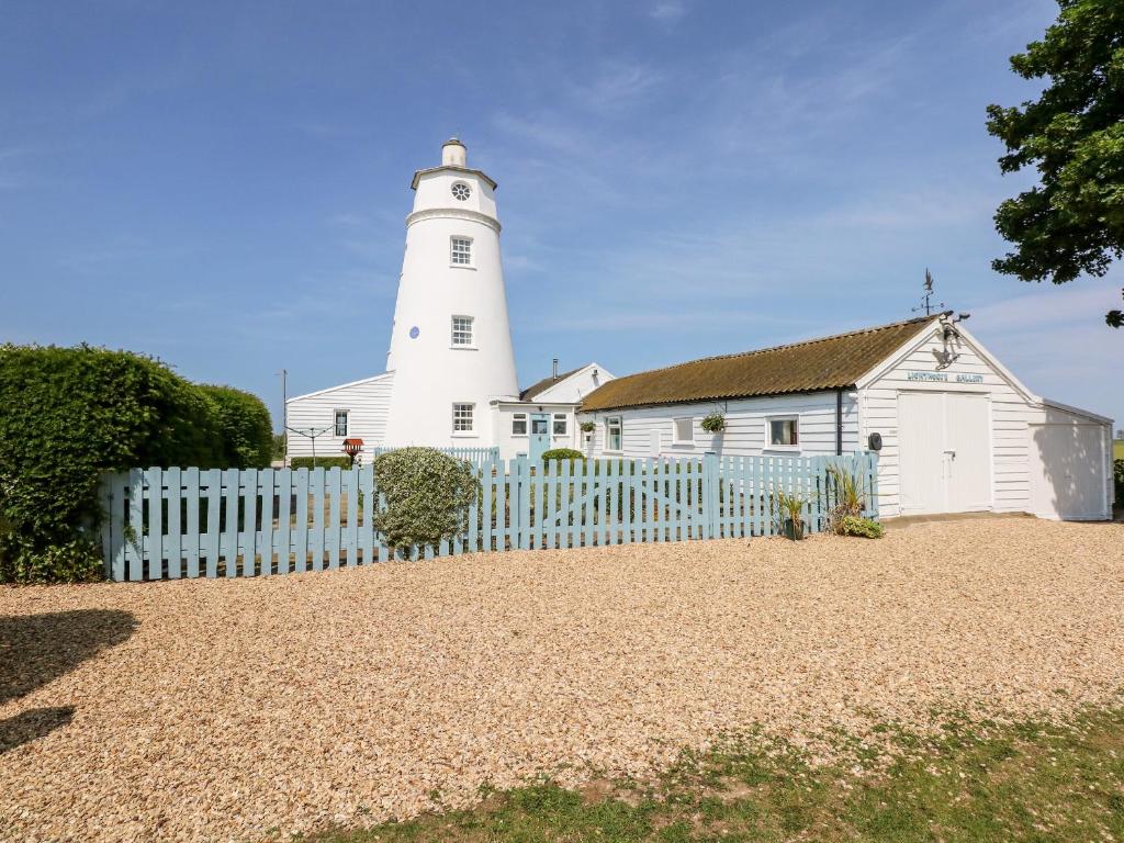 斯伯丁The Sir Peter Scott Lighthouse的灯塔前面有白色的围栏