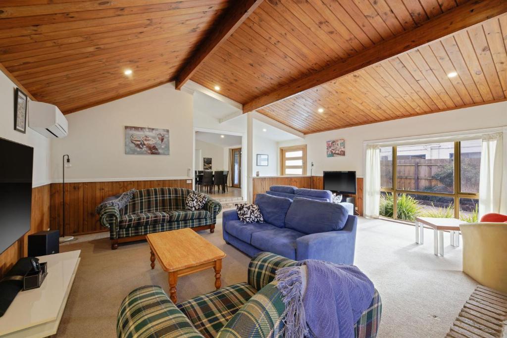 卡尔斯Thompson House Phillip Island的客厅配有蓝色的沙发和电视