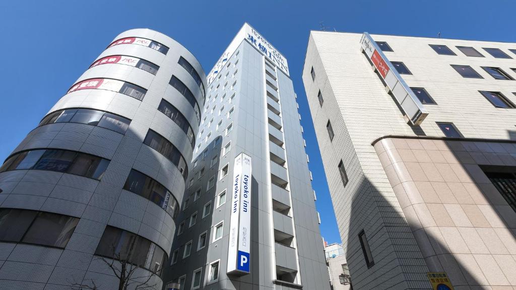 柏市Toyoko Inn Kashiwa eki Nishi guchi的三座高楼彼此相邻