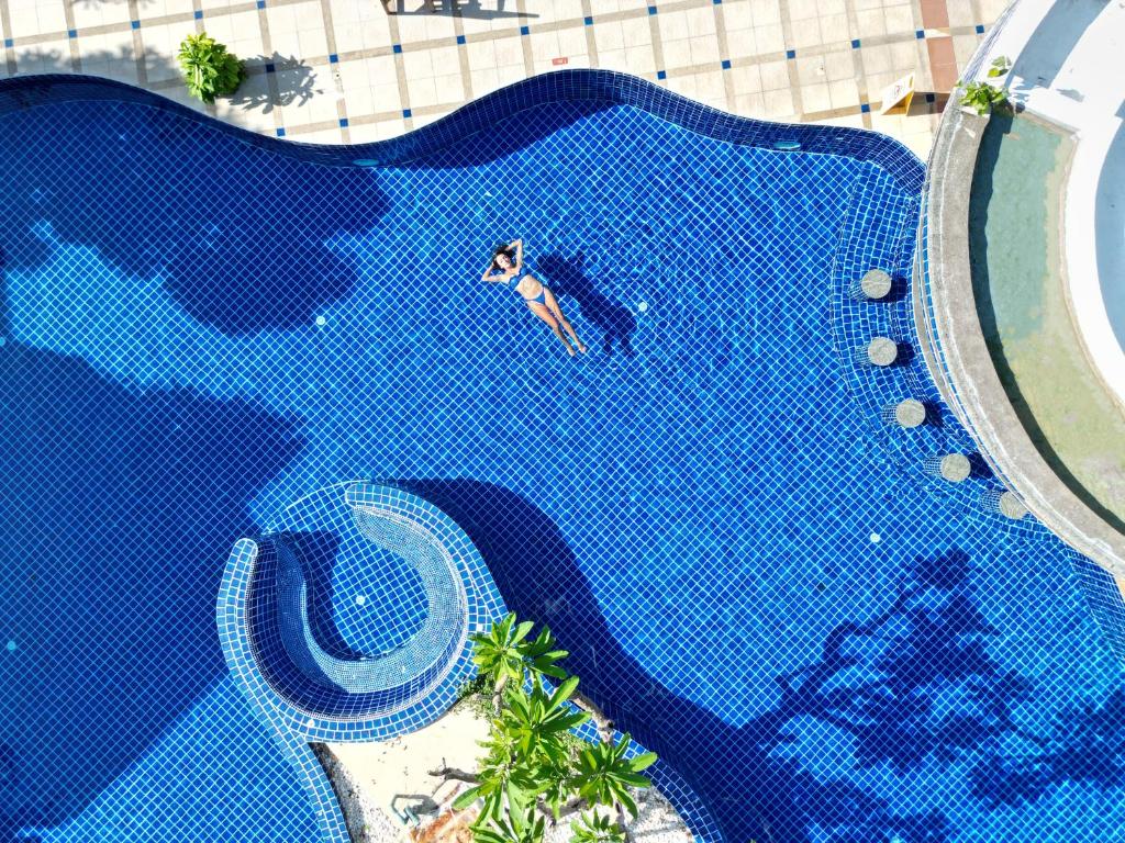 芭东海滩Phuket Leelavadee Hua Ting Resort的游泳池游泳男子的头顶景色