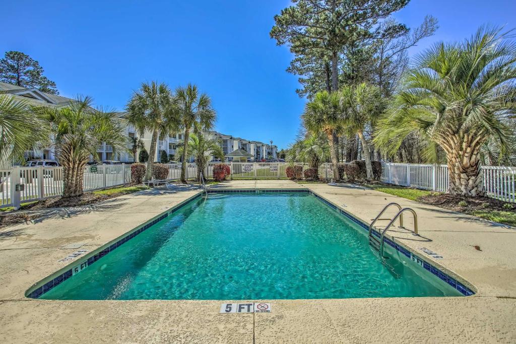 默特尔比奇Myrtle Beach Condo Private Balcony and Resort Perks的棕榈树庭院内的游泳池