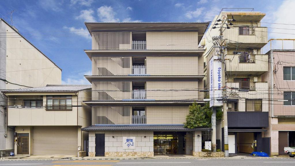 京都Toyoko Inn Kyoto Gojo omiya的一座高大的建筑,旁边有一个标志