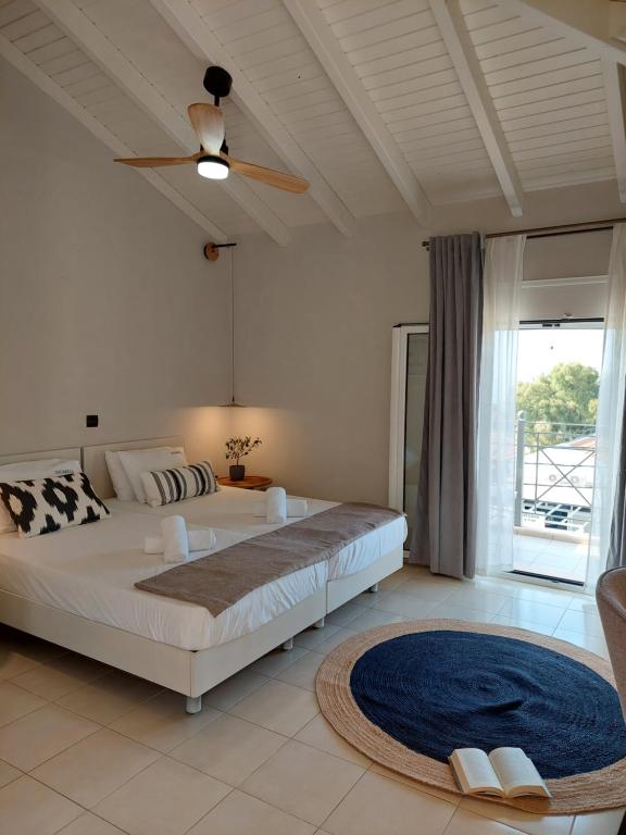 斯卡拉Nikkos Apartments的一间卧室配有一张大床和吊扇