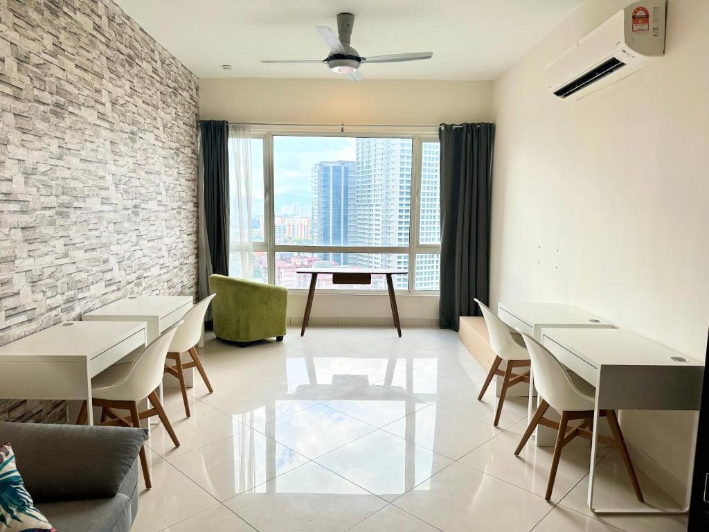 吉隆坡Comfy+ by ARH KLCC的餐厅设有桌椅和大窗户。