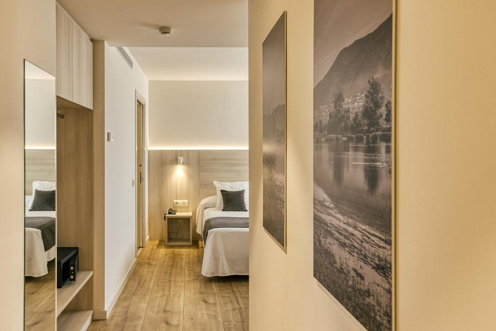 卡斯特罗·德波利亚斯Hotel Emporium - Adults Only的一间卧室设有两张床,墙上挂着一幅画