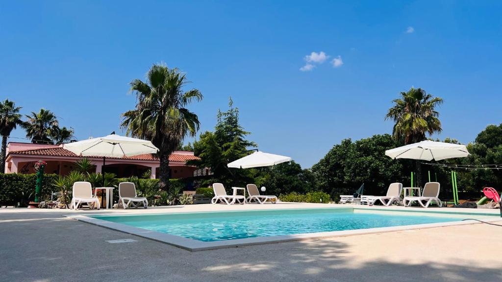 托雷桑塔萨宾娜I Giardini Dell'Agave的一个带椅子和遮阳伞的游泳池
