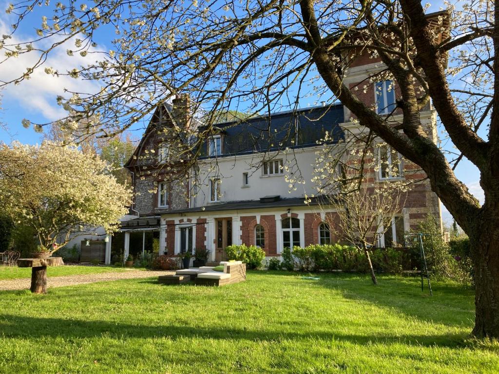 Saint-Laurent-de-BrévedentBEAU STUDIO DANS VILLA DE CHARME的一座带草地庭院的大型白色房屋
