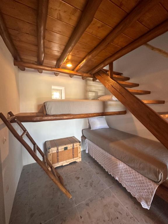 米克诺斯城Rizes Mykonos - Folklore Farmstead的客房设有两张双层床和木制天花板。