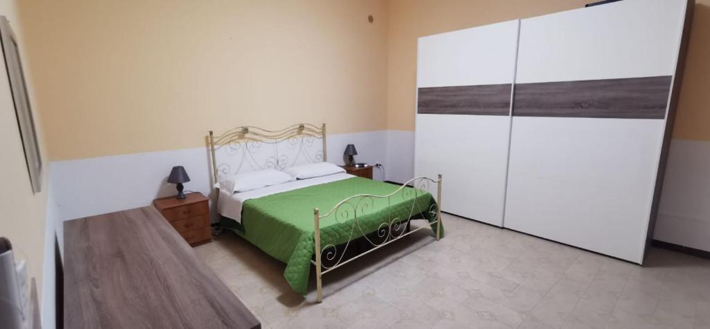 诺托玛丽娜Casa Falconara的一间位于客房内的带绿色和白色床的卧室
