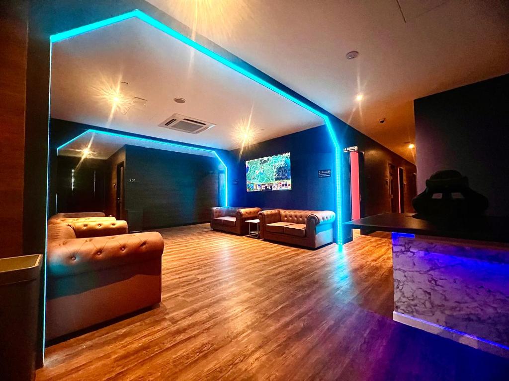 新加坡Arena eSports @ Orchard的带沙发和电视的客厅以及蓝色灯光