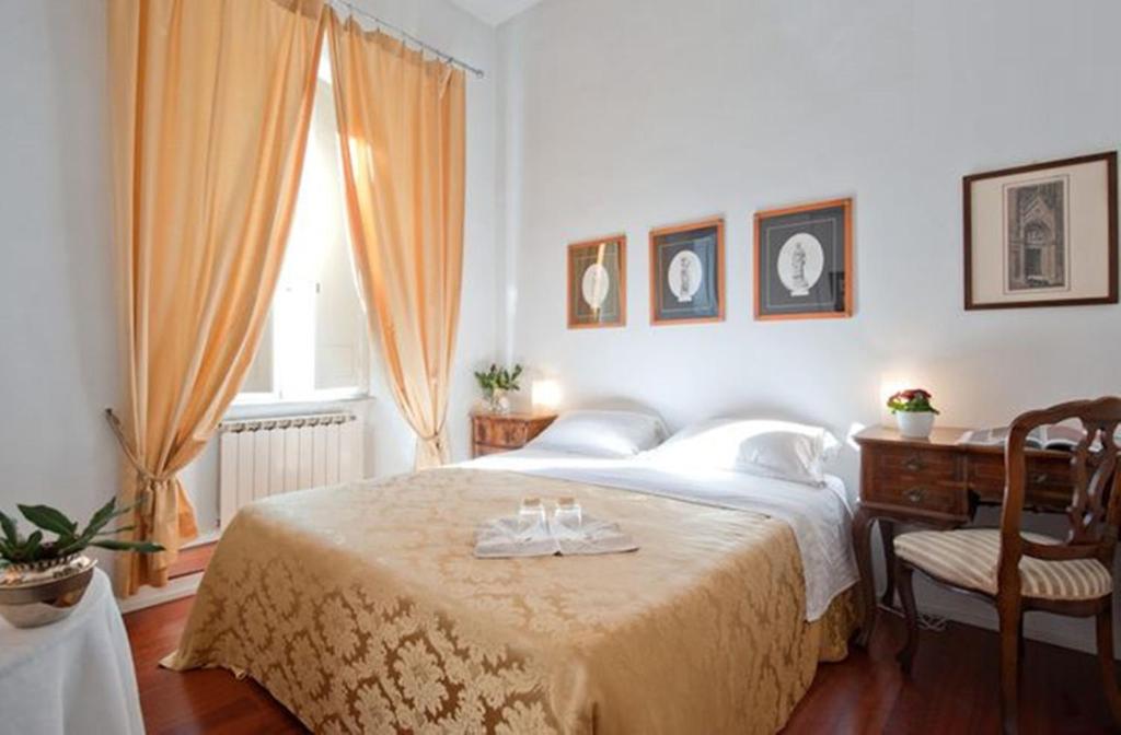 罗马克罗里迪罗马住宿加早餐旅馆的一间卧室配有一张带桌子和窗户的床