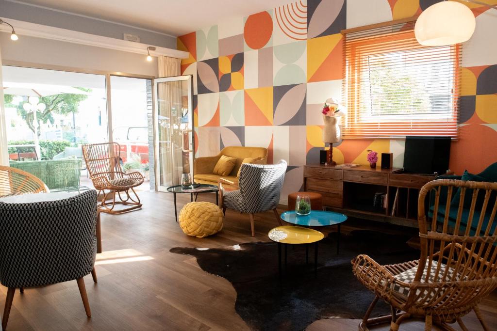 里乔内米拉贝拉酒店的客厅配有色彩缤纷的图案墙壁和椅子