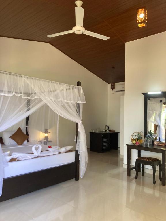 锡吉里亚The View Hotel Sigiriya的一间卧室配有一张带天蓬和桌子的床