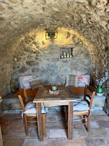 卡尔热斯charmante bergerie à Cargese tres belle vue mer avec jardin的石墙客房内的桌椅