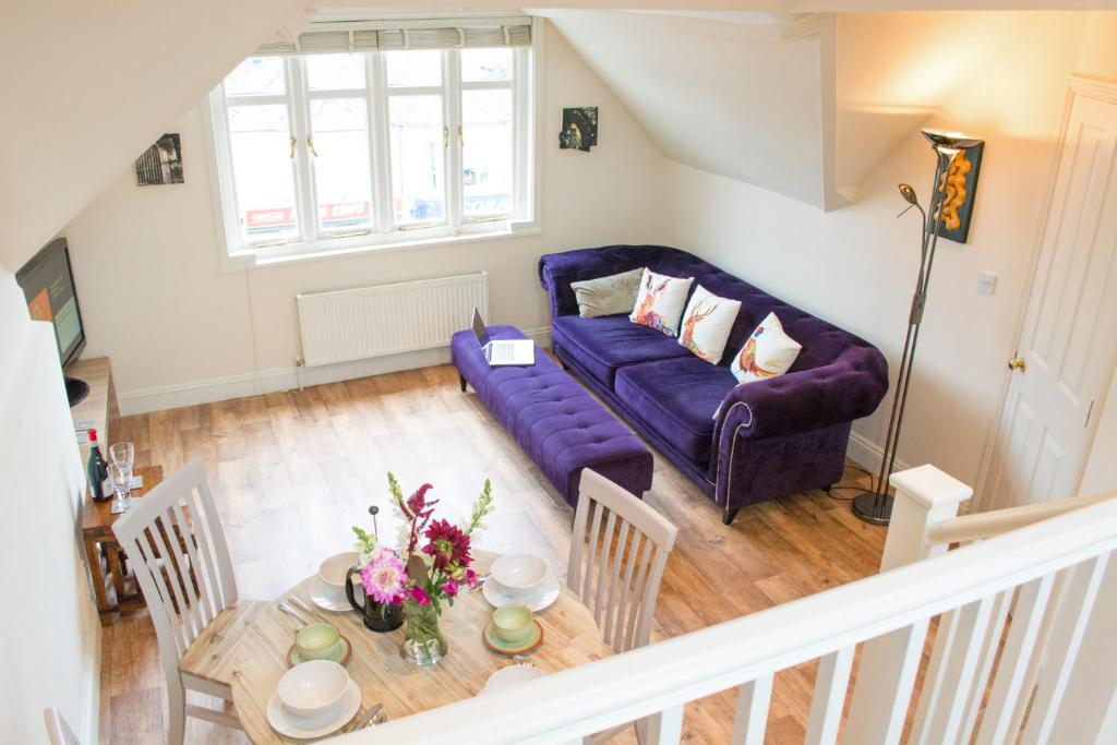 诺里奇York Terrace Apartments - Norwich City的客厅配有紫色沙发和桌子
