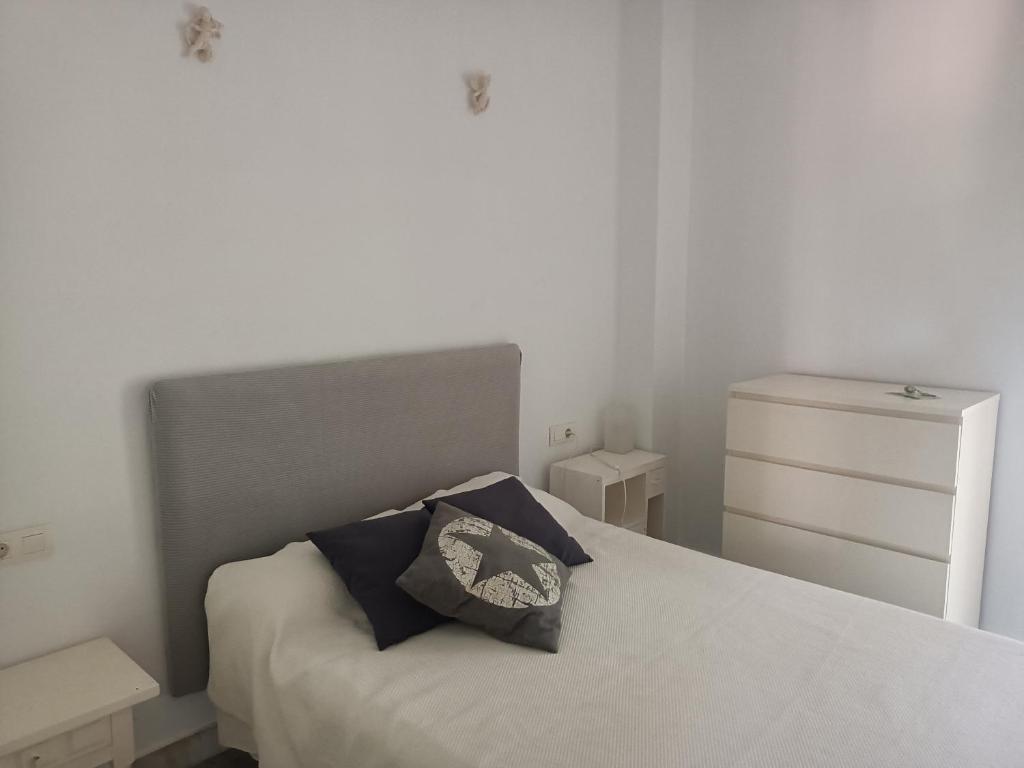 韦尔瓦Islantilla - Bajo con Jardín en Golf Islantilla的卧室配有白色的床和枕头