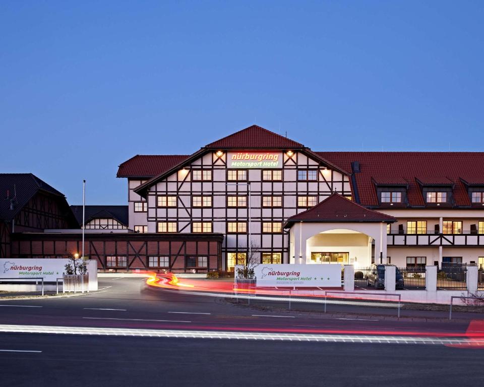 尼尔堡Lindner Hotel Nurburgring Motorsport, part of JdV by Hyatt的前面有一条路的大建筑
