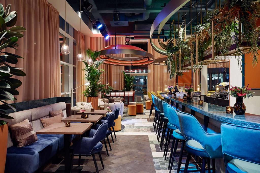 安特卫普Lindner Hotel Antwerp, part of JdV by Hyatt的一间设有蓝色椅子的餐厅和一间酒吧