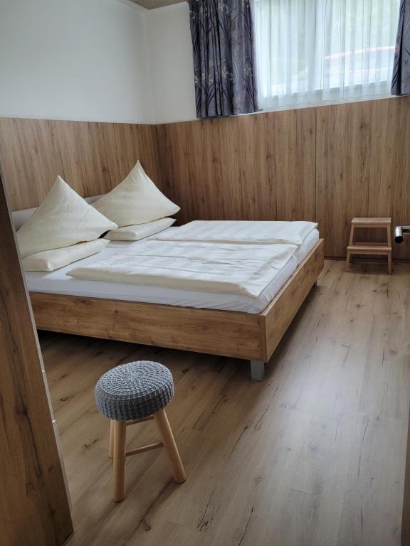 米尔施塔特Lucashof Millstättersee的一间卧室配有一张大床和一把椅子